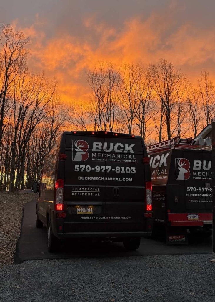 Buck Mechanical service vans parked at sunset with company branding visible on the vehicles.